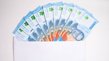 THR (tunjangan hari raya) ve maaş için beyaz zarf içinde Endonezya banknotlarının yeni baskısı.