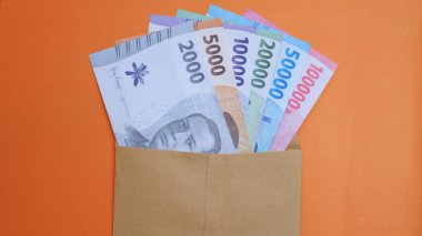 THR (tunjangan hari raya) ve maaş için kahverengi zarf içinde Endonezya banknotlarının yeni baskısı.
