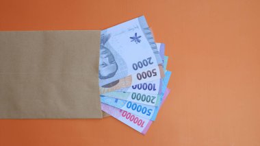 THR (tunjangan hari raya) ve maaş için kahverengi zarf içinde Endonezya banknotlarının yeni baskısı.