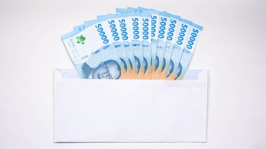 THR (tunjangan hari raya) ve maaş için beyaz zarf içinde Endonezya banknotlarının yeni baskısı.