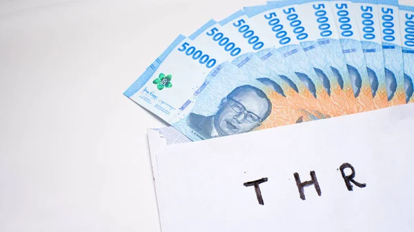 stock image New edition of Indonesian banknotes in a white envelope for THR (tunjangan hari raya) and salary.