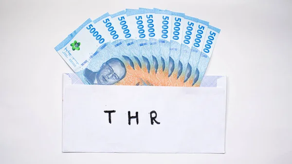 stock image New edition of Indonesian banknotes in a white envelope for THR (tunjangan hari raya) and salary.