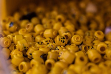 London, UK - 2023: Bunch of Lego heads of varying designs and expressions at Lego World in London for people to costumize their own character or figure.