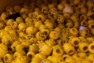 London, UK - 2023: Bunch of Lego heads of varying designs and expressions at Lego World in London for people to costumize their own character or figure.