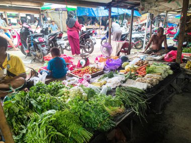 Geleneksel bir pazarda sebze satan bir satıcının fotoğrafı