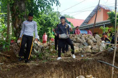 Padang Jaya Köyü sakinleri istinat duvarı inşa etmek için birlikte çalışıyorlar.