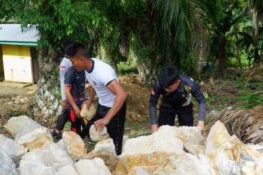 Padang Jaya Köyü sakinleri istinat duvarı inşa etmek için birlikte çalışıyorlar.
