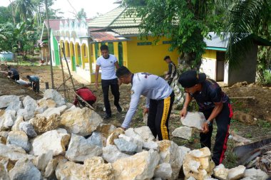 Padang Jaya Köyü sakinleri istinat duvarı inşa etmek için birlikte çalışıyorlar.