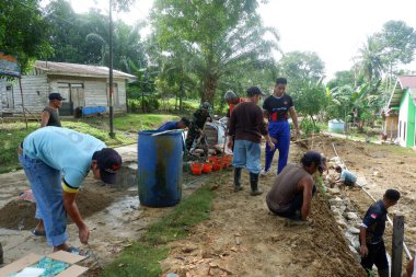 Padang Jaya Köyü sakinleri istinat duvarı inşa etmek için birlikte çalışıyorlar.