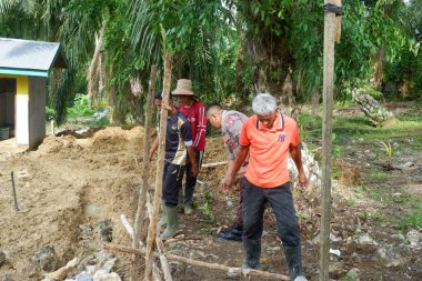  Padang Jaya Köyü sakinleri istinat duvarı inşa etmek için birlikte çalışıyorlar.