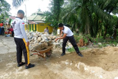  Padang Jaya Köyü sakinleri istinat duvarı inşa etmek için birlikte çalışıyorlar.