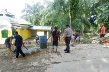  Padang Jaya Köyü sakinleri istinat duvarı inşa etmek için birlikte çalışıyorlar.
