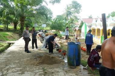  Padang Jaya Köyü sakinleri istinat duvarı inşa etmek için birlikte çalışıyorlar.