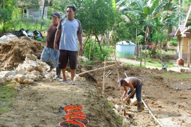  Padang Jaya Köyü sakinleri istinat duvarı inşa etmek için birlikte çalışıyorlar.