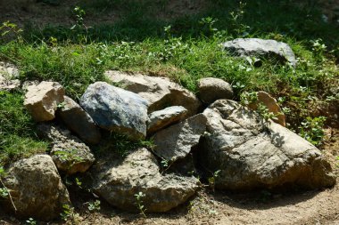 Tepesinde yeşil çimenler olan kayalar.