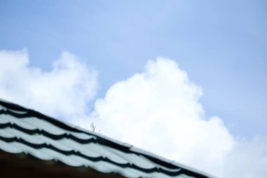 Arka planda bulutlu ve berrak gökyüzü olan çatı