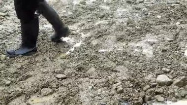 Yağmurdan sonra kayalık bir köy yolunda çamurlu su birikintilerinin manzarası