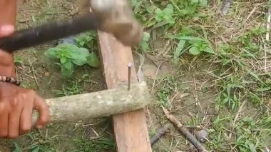 Bir insanın eli çekiç kullanarak tahtayı çiviliyor. Marangozluk kavramı için uygun