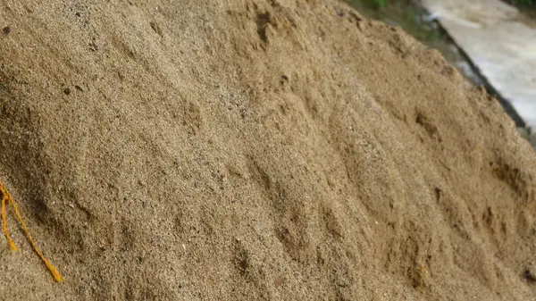 İnşaat amaçları için kullanılan bir yığın altın sarısı kum. Kumun dokusu açıkça görülebilir, yoğun ve temiz taneler gösteriyor..