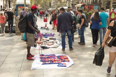 Barselona, İspanya - 26 Eylül 2016: Barselona 'daki Ramblas' ta manteros olarak bilinen siyah Afrikalı sokak satıcıları ve onların mallarına bakan insanlar. Bu eylemler yasa dışı, bu yüzden polis geldiğinde hemen kaçmaya hazırlanıyorlar..