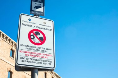 Barselona, İspanya - 30 Eylül 2016: Barselona, İspanya 'daki battaniye satıcılarından ürün almamayı tavsiye eden açık hava panosu. Bu faaliyet 50 Euro para cezasıyla cezalandırılabilir. Bilgi üç dilde yazılmıştır; Katalanca, İspanyolca ve İngilizce