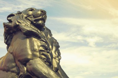 Detail of statue of a king lion, which belongs to Christopher Columbus monument. It is located in Plaza del Portal de la Pau in Barcelona, Spain. Columbus discovered America in 1492. clipart