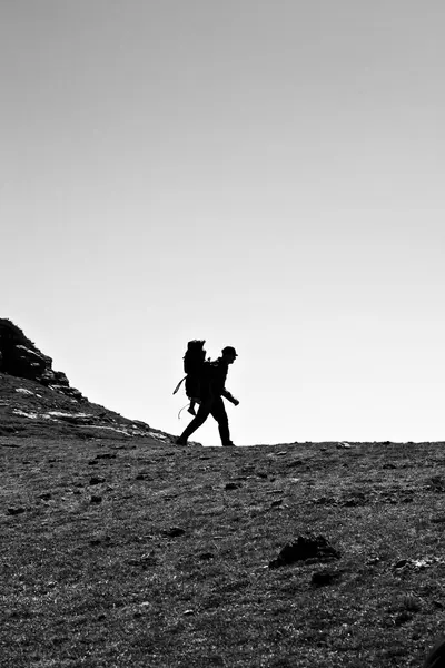 stock image Silhouette of man walking in the mountains of Montseny, Catalonia, with his child hanging on his back