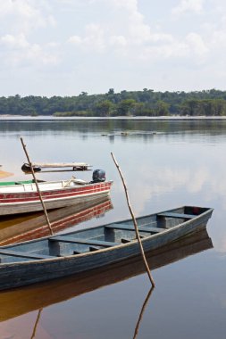 Brezilya 'da Amazon Nehri kıyısına demirlemiş eski ahşap tekneler. Gökyüzü suyu yansıtıyor..