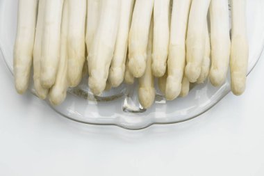 İzole edilmiş bir tabağa yerleştirilmiş beyaz kuşkonmaz grubu.