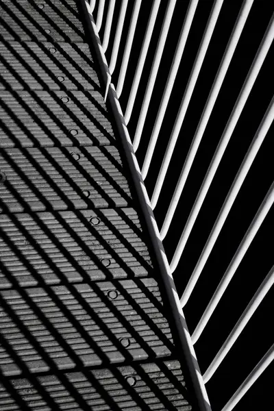 stock image Geometric composition with shadows, planks and iron rails of a bridge in black and white