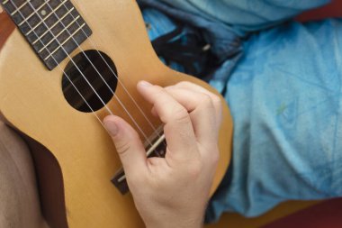 Adam bir hamak rahatlatıcı ve ukulele oynarken detay.