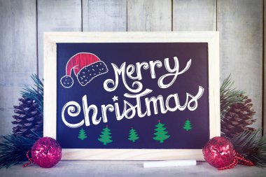Ahşap bir arka planda noel süslemesi olan tebeşir tahtası üzerinde 