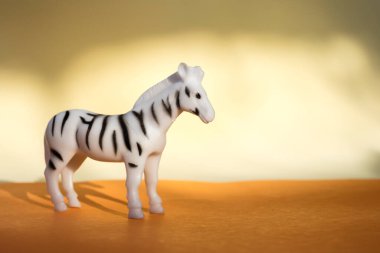 Turuncu arka planda plastik zebra minyatürü.