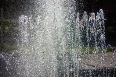 fountain with jets of water white and gray-silver color close-up in the summer in the heat