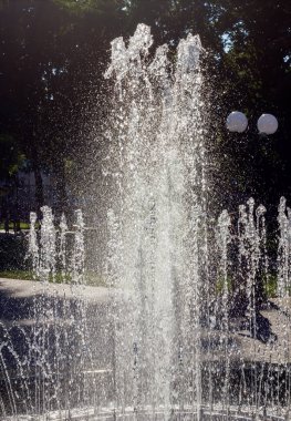 fountain with jets of water white and gray-silver color close-up in the summer in the heat, vertical photo