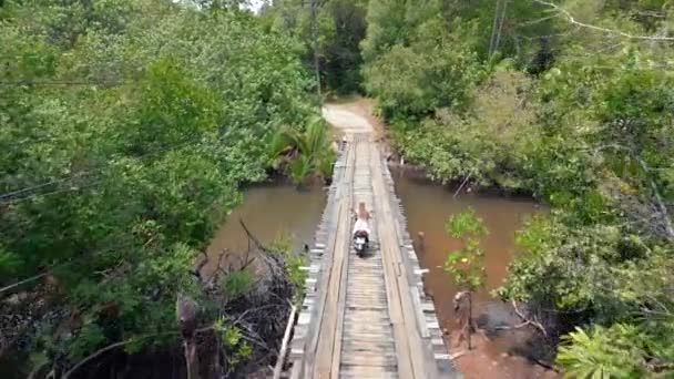 아시아 의나무 다리를 가로지르는 스쿠터를 여자의 — 비디오