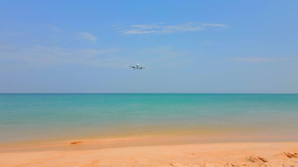 美しい熱帯のビーチとタイのプーケットのターコイズブルーの水の上に着陸する飛行機 リゾートに着陸する飛行機 — ストック動画