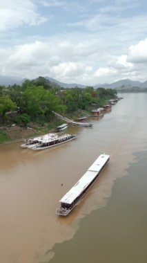 Yavaş tekneyle Laos 'u keşfediyorum. Luang Prabang, Laos 'taki görkemli Mekong Nehri boyunca turistlerin dolaştığı geleneksel bir teknenin hava manzarası.. 