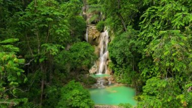 Laos 'ta sakin bir şelale ve tropikal yeşil ormanın inanılmaz hava manzarası.