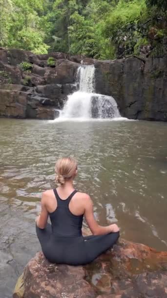 在泰国热带雨林的一个令人惊奇的瀑布前 美丽的年轻女子正在练习冥想 — 图库视频影像