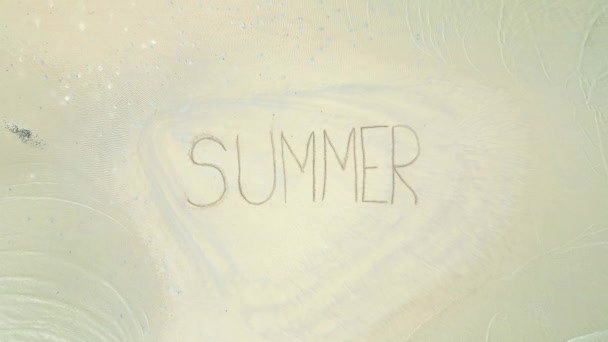 透明な水で白い砂に書かれたSummerサインのトップビュー — ストック動画