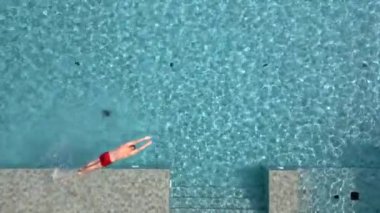 Yazın havuza atlayan adam ağır çekimde, en üst görüntüde.