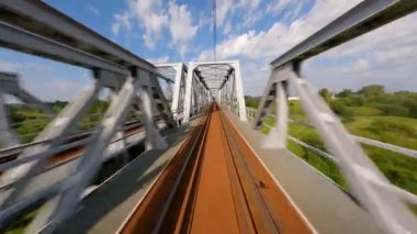 FPV insansız hava aracı yazın tren köprüsünde hızla uçuyor..