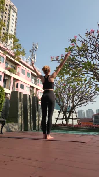 在一座大城市里 一位白人妇女在摩天大楼的屋顶上练习瑜伽 — 图库视频影像