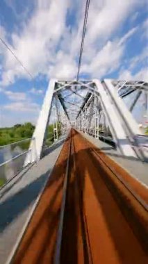 FPV insansız hava aracı yazın tren köprüsünde hızla uçuyor..