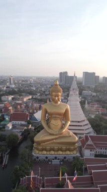 Dev Altın Buda 'nın günbatımında muhteşem hava manzarası. Arka planda güzel bir şehir silueti var. Şehirlerin zengin kültürünü ön plana çıkarıyor. Bangkok, Tayland.