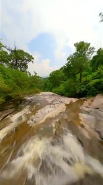 Dinamik FPV insansız hava aracı, Chiang Mai bölgesindeki Tayland 'ın kuzeyinde inanılmaz bir şelale ve tropikal ağaçlar üzerinde uçuyor..