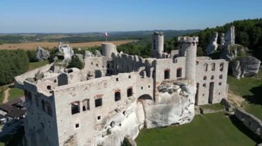 Güneşli bir günde Polonya 'nın yeşil dağlıklarında bir ortaçağ şatosunun havadan görünüşü.