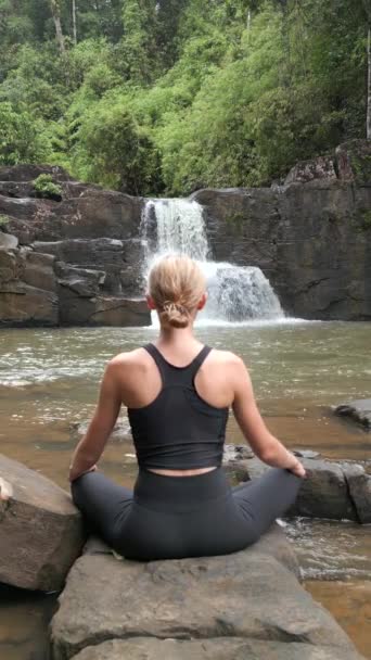 在泰国热带雨林的瀑布前 一位高加索女人正在练习冥想 — 图库视频影像