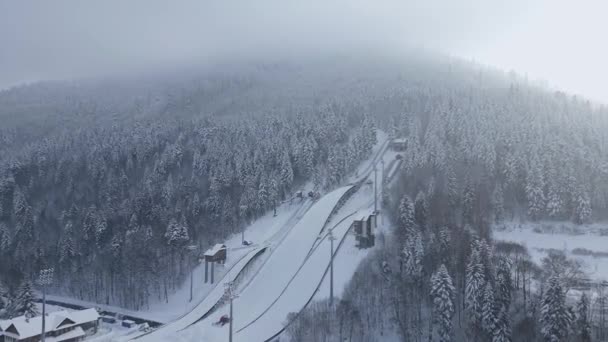山の冬の森で雪のスキージャンプの空中ビュー — ストック動画